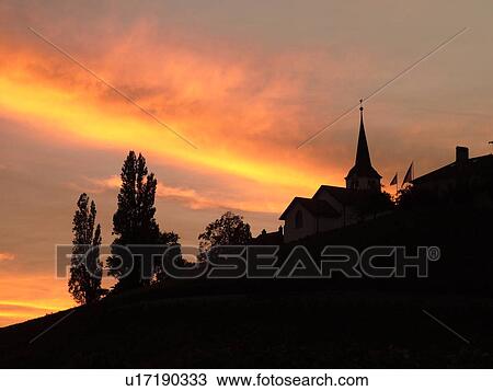 Stock Image -  Switzerland, Europe, Vaud, Fechy, La Cote, sunset, village, silhouette. Fotosearch