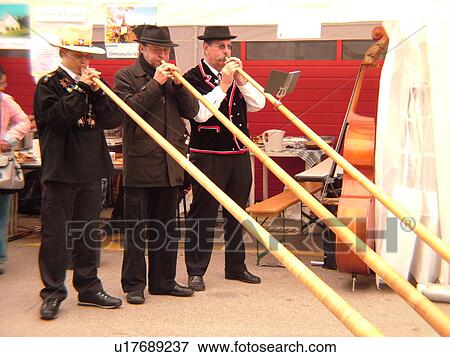 Stock Photo -  Switzerland, Europe, Vaud, St. Cergues, La Desalpe, festival, men playing alphorns. Fotosearch