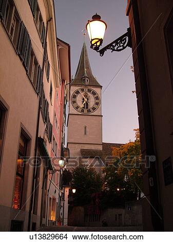 Picture -  Switzerland, Europe, Zurich, Zuerich, St. Peters Kirche, clock tower, evening, street lamp. Fotosearch