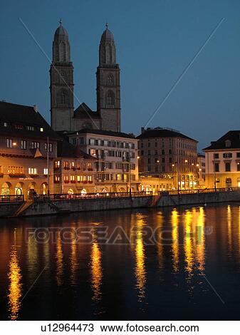 Stock Image -  Switzerland, Europe, Zurich, Zuerich, Limmat River, Grossmunster Cathedral, Limmatquai, evening. Fotosearch
