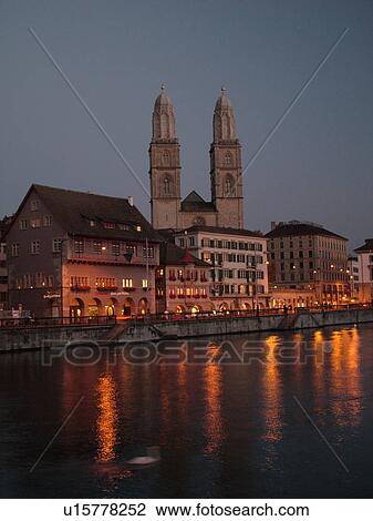 Stock Image -  Switzerland, Europe, Zurich, Zuerich, Limmat River, Grossmunster Cathedral, Limmatquai, evening. Fotosearch