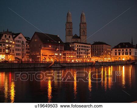 Stock Image -  Switzerland, Europe, Zurich, Zuerich, Limmat River, Grossmunster Cathedral, Limmatquai, evening. Fotosearch