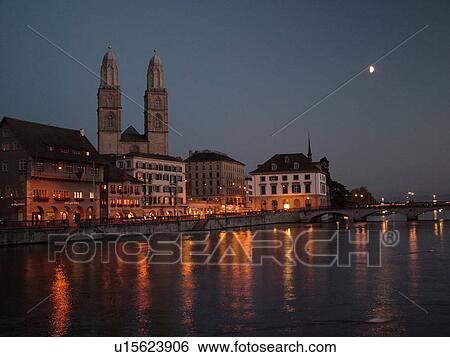Stock Photograph -  Switzerland, Europe, Zurich, Zuerich, Limmat River, Grossmunster Cathedral, Limmatquai, evening. Fotosearch