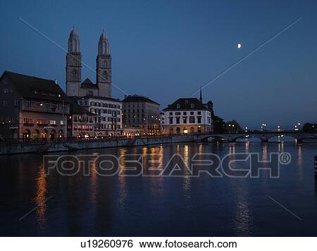 Stock Photograph -  Switzerland, Europe, Zurich, Zuerich, Limmat River, Grossmunster Cathedral, Limmatquai, evening. Fotosearch