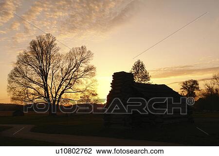 Stock Image -  Valley Forge, PA, Pennsylvania, Valley Forge National Historical Park, log hut, sunset. Fotosearch
