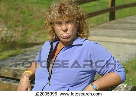 West Chester, PA, Pennsylvania, Hershey's Mill Chester County, 50 year old woman sitting on a park bench sticking out her tongue View Large Photo Image Stock Photograph - West Chester, PA, Pennsylvania, Hershey's Mill Chester County, 50 year old woman sitting on a park bench sticking out her tongue. Fotosearch