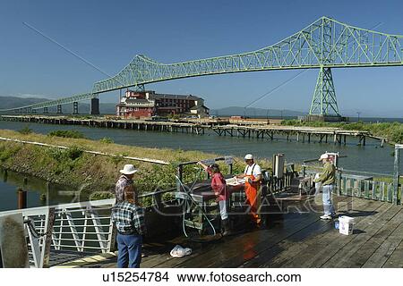 Picture -  Astoria, OR, Oregon, Pacific Ocean, Pacific Coast Scenic Byway, Rt Route, Highway 101, Columbia River, Riverfront, marina, fisherman, cleaning fish. Fotosearch