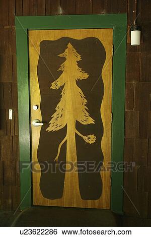 Stock Photograph -  CA, California, Pacific Ocean, Redwood National and State Parks, Prairie Creek Redwoods State Park, Prairie Creek Visitor Center, redwood tree etched in wooden door. Fotosearch