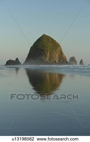 Stock Image -  Cannon Beach, OR, Oregon, Pacific Ocean, Pacific Coast Scenic Byway, Rt Route, Highway 101, Cannon Beach, Haystack Rock, reflection. Fotosearch