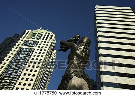 Stock Image -  Charlotte, NC, North Carolina, Downtown, The Square, Mother lifting child to sky bronze statue hope for city's future. Fotosearch