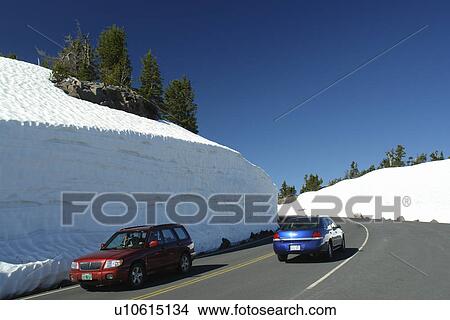 Picture -  Crater Lake National Park, OR, Oregon, Cascade Range, Volcanic Legacy Scenic Byway, Rim Drive, side of road packed high with snow. Fotosearch