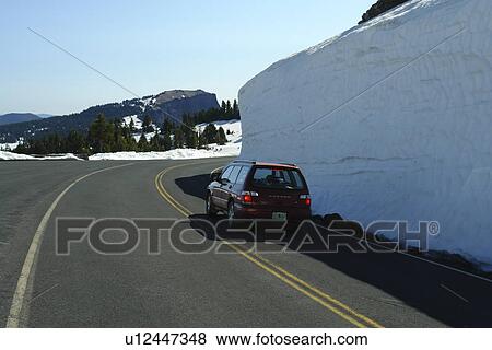 Stock Photo -  Crater Lake National Park, OR, Oregon, Cascade Range, Volcanic Legacy Scenic Byway, Rim Drive, side of road packed high with snow. Fotosearch