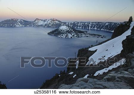 Stock Photograph -  Crater Lake National Park, OR, Oregon, Cascade Range, Volcanic Legacy Scenic Byway from Rim Drive, Wizard Island, sunset. Fotosearch