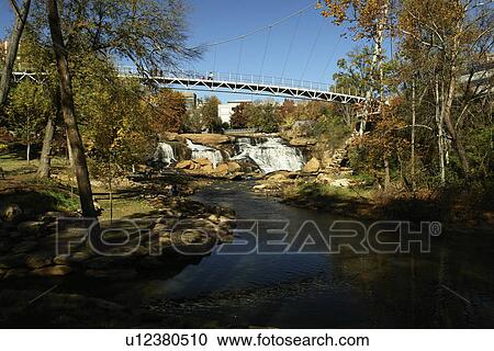 Stock Image -  Greenville, SC, South Carolina, Reedy River Falls Historic Park, autumn, foot bridge. Fotosearch