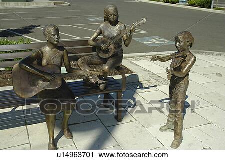 Stock Image -  Medford, OR, Oregon, downtown, statue of three girls playing instruments. Fotosearch