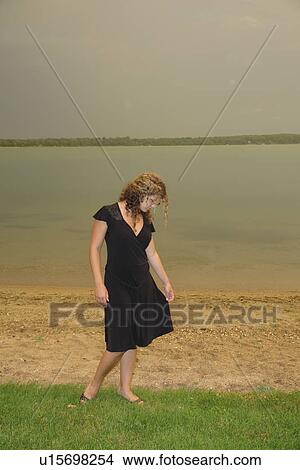 Alexandria, MN, Minnesota, young woman in black dress by Maple Lake View Large Photo Image Picture - Alexandria, MN, Minnesota, young woman in black dress by Maple Lake. Fotosearch