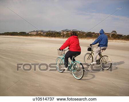 Stock Photo -  couple biking on the beach, Hilton Head Island, Low Country, South Carolina, SC, Atlantic Ocean. Fotosearch