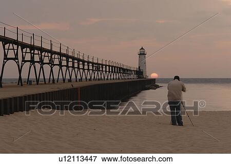 Manistee, MI, Michigan, Lake Michigan, North Pierhead Lighthouse, man photographing sunset View Large Photo Image Stock Photo - Manistee, MI, Michigan, Lake Michigan, North Pierhead Lighthouse, man photographing sunset. Fotosearch