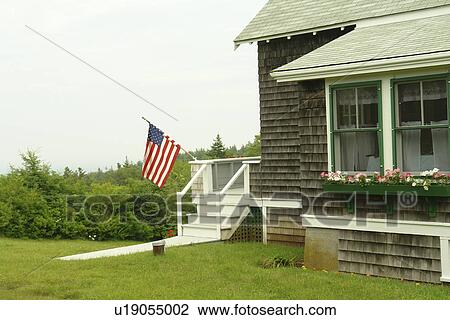 Stock Image -  Monhegan Island, ME, Maine, home, US Flag. Fotosearch