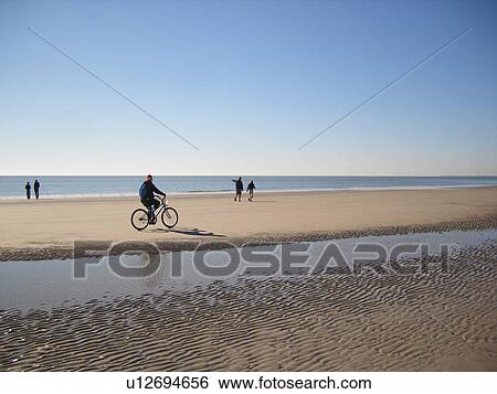 Stock Photograph -  people biking and walking on the beach, Hilton Head Island, Low Country, South Carolina, SC, Atlantic Ocean. Fotosearch