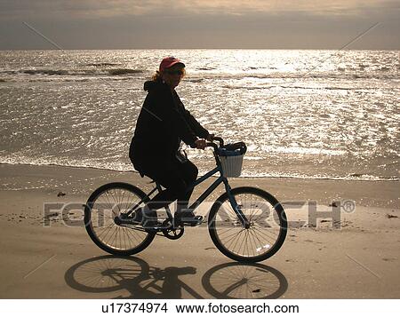 Picture -  woman biking on the beach, Hilton Head Island, Low Country, South Carolina, SC, Atlantic Ocean. Fotosearch