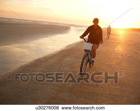 Stock Photo -  woman biking on the beach, Hilton Head Island, Low Country, South Carolina, SC, Atlantic Ocean. Fotosearch