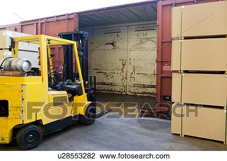 Stock Image - Fork Lift Truck loading industrial railway carriage. Fotosearch
