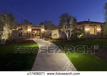 Stock Image - Garden path leading to residential front gate at dusk. Fotosearch