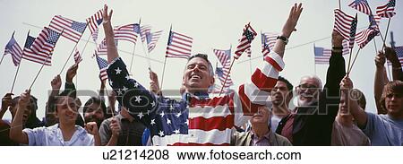 Happy mid adult man with crowd waving North American flags in background View Large Photo Image Stock Photo - Happy mid adult man with crowd waving North American flags in background. Fotosearch