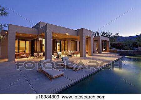 Stock Photo - House exterior with pool at dusk. Fotosearch