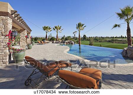Looking over sun lounges to pool and garden View Large Photo Image Picture - Looking over sun lounges to pool and garden . Fotosearch