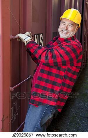 Middle Aged worker standing in industrial railway carriage View Large Photo Image Stock Photo - Middle Aged worker standing in industrial railway carriage. Fotosearch