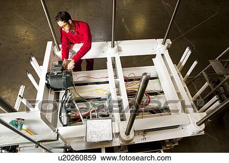 Overhead view of technician repairing motor on electrical circuit View Large Photo Image Stock Photo - Overhead view of technician repairing motor on electrical circuit . Fotosearch