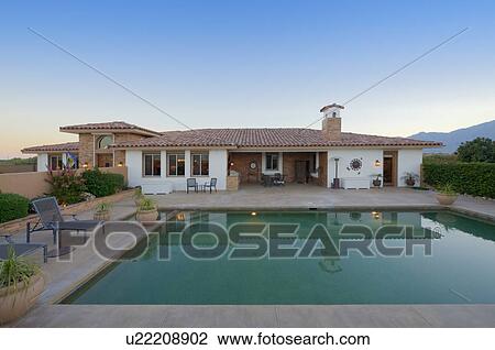 Stock Image - straight view of bungalow exterior with swimming pool. Fotosearch