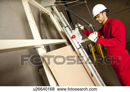 Technician operating heavy duty machinery in manufacturing plant View Large Photo Image Stock Photo - Technician operating heavy duty machinery in manufacturing plant. Fotosearch