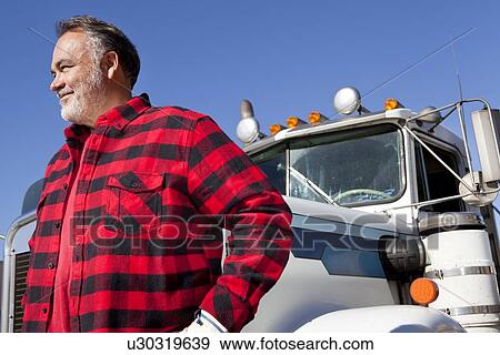 Stock Photo - Trucker standing in front of Cargo truck. Fotosearch