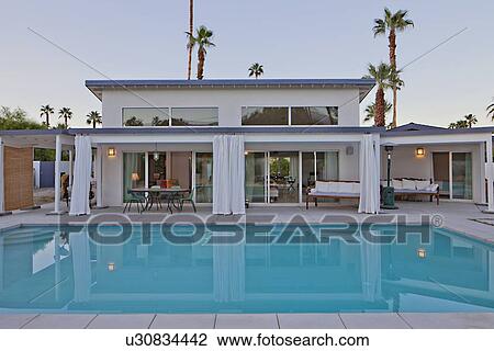 view across a pool to patio of luxury home View Large Photo Image Stock Image - view across a pool to patio of luxury home. Fotosearch