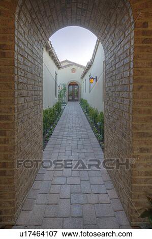 View through archway down path to French doors of luxury home View Large Photo Image Stock Photo - View through archway down path to French doors of luxury home. Fotosearch
