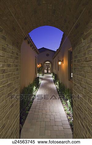 View through archway down path to French doors at dusk View Large Photo Image Stock Photography - View through archway down path to French doors at dusk. Fotosearch