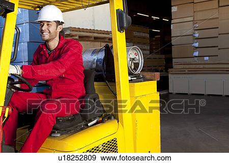 Warehouse worker using forklift truck View Large Photo Image Stock Photo - Warehouse worker using forklift truck. Fotosearch