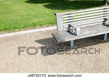 Stock Image - Close-up view of Wooden bench in London Park. Fotosearch