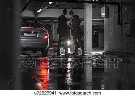 Full length of businessmen giving and receiving envelop in basement View Large Photo Image Stock Image - Full length of businessmen giving and receiving envelop in basement. Fotosearch