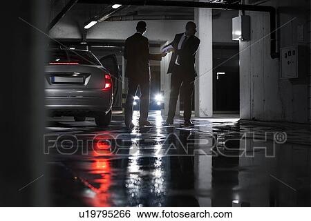 Full length of businessmen giving and receiving envelop in basement View Large Photo Image Stock Photograph - Full length of businessmen giving and receiving envelop in basement. Fotosearch