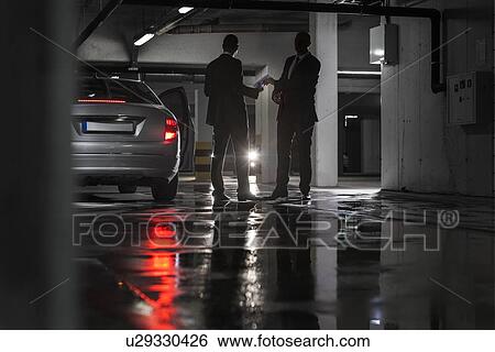 Full length of businessmen giving and receiving envelop in basement View Large Photo Image Stock Photograph - Full length of businessmen giving and receiving envelop in basement. Fotosearch