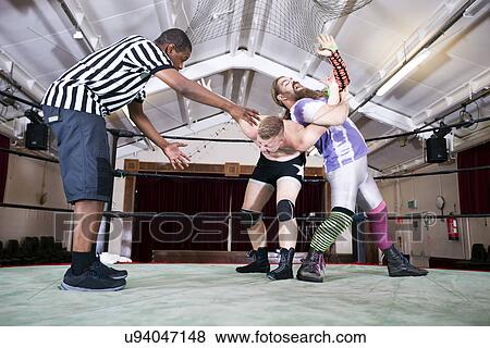 Full-length of wrestlers fighting while referee gesturing in ring View Large Photo Image Stock Photo - Full-length of wrestlers fighting while referee gesturing in ring. Fotosearch