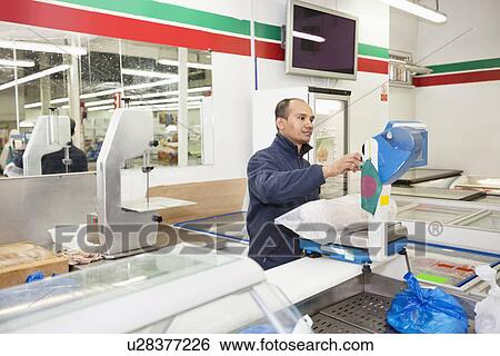 Male worker weighing products in grocery store View Large Photo Image Stock Photograph - Male worker weighing products in grocery store. Fotosearch