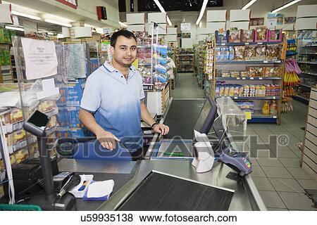 Portrait of store clerk standing at counter in supermarket View Large Photo Image Stock Photo - Portrait of store clerk standing at counter in supermarket. Fotosearch