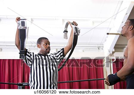 Referee showing champion belt while looking at wrestler in ring View Large Photo Image Stock Image - Referee showing champion belt while looking at wrestler in ring. Fotosearch