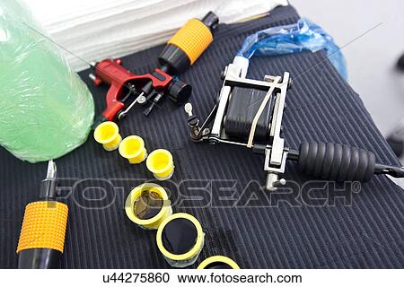 Tattoo gun and ink caps on table in shop View Large Photo Image Stock Image - Tattoo gun and ink caps on table in shop. Fotosearch