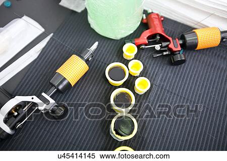 Tattoo gun and ink caps on table in shop View Large Photo Image Stock Photography - Tattoo gun and ink caps on table in shop. Fotosearch